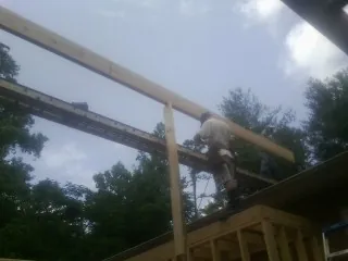 Carpenter setting a ridge beam over a new addition frame — Ice Dam Removal by Roofing Brothers in Woodland Hills