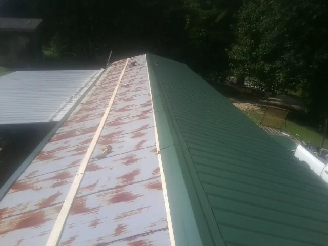 Old rusted panels beside newly installed green metal roofing — Wind Damage Roof Repair by Roofing Brothers in Woodland Hills