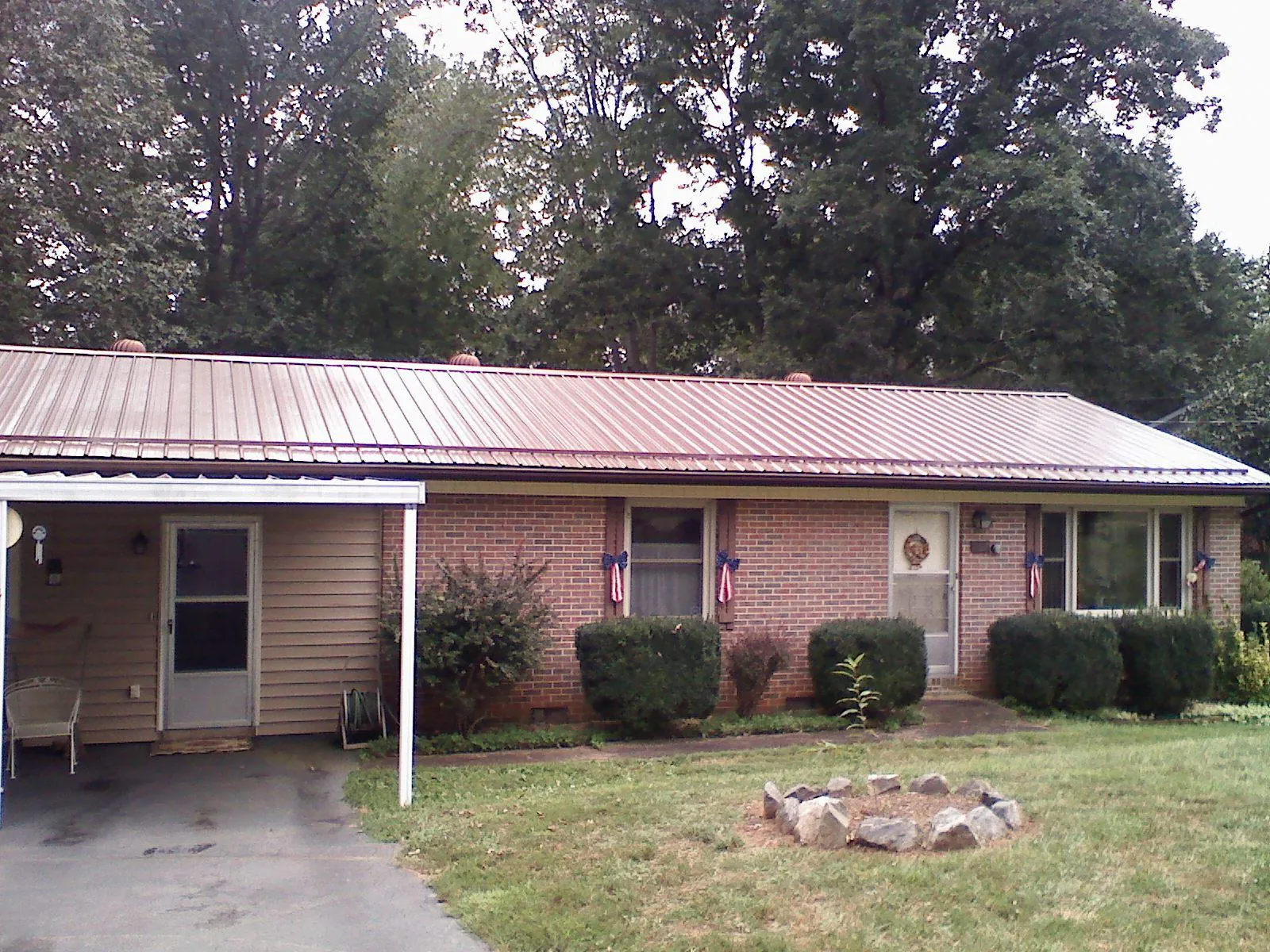 Bronze metal roof and carport on a brick ranch home — Roof Repair work by our crew in Woodland Hills